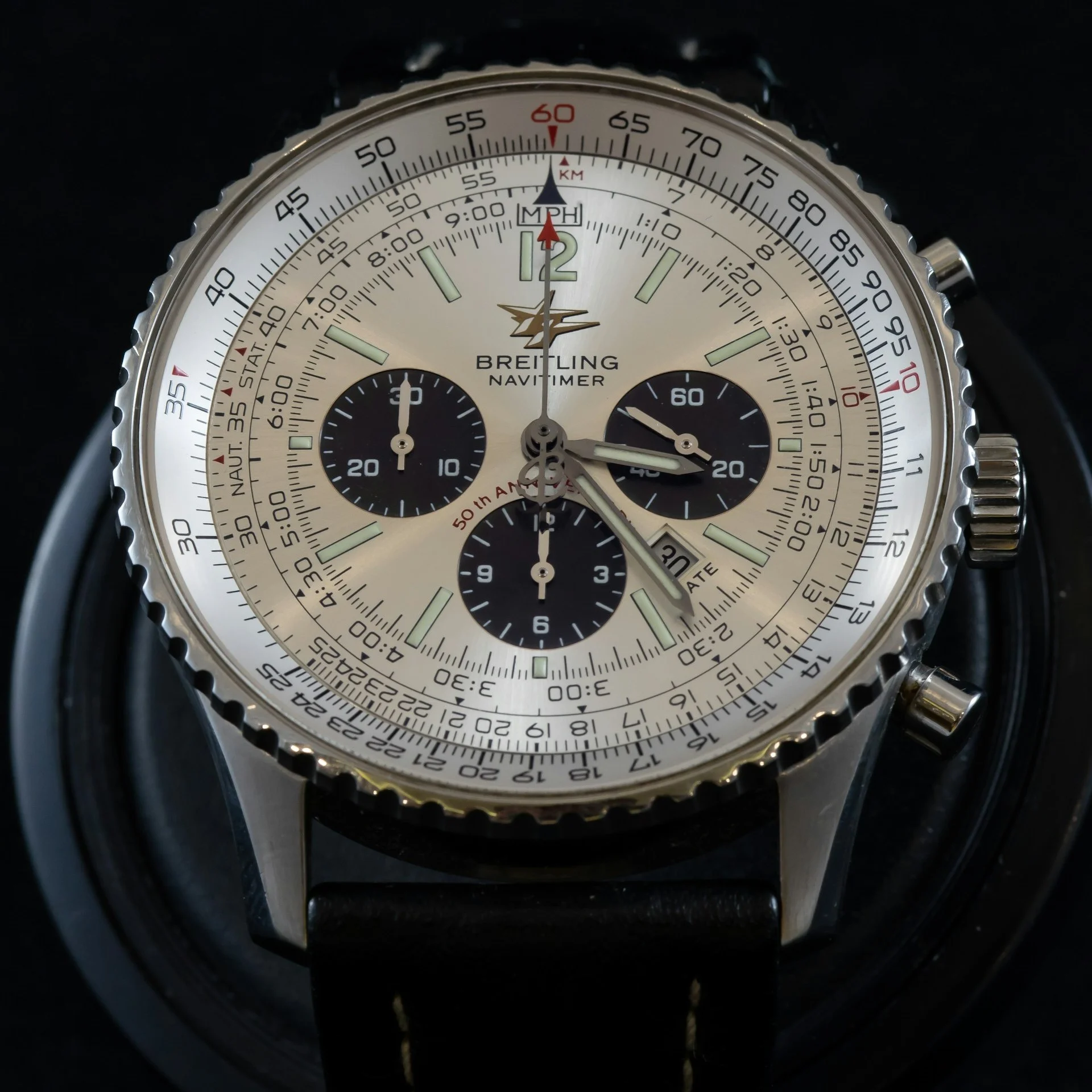 A close-up of a Breitling Navitimer Pilot watch featuring a beige dial with an inner bezel and markings for various calculations.