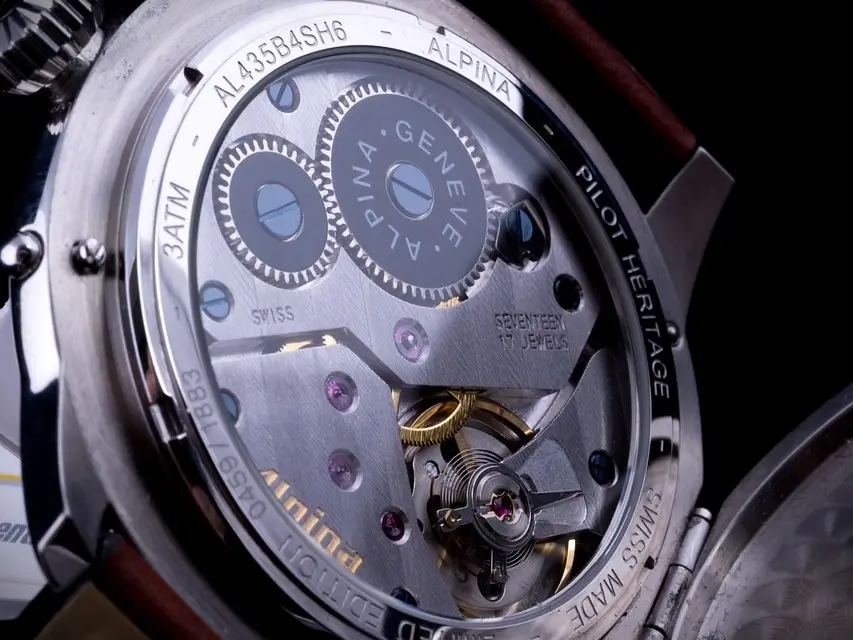 Close-up of a watch movement visible through an exhibition case back, showcasing intricate gears and mechanics.
