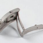 Close-up of a stainless steel folding watch clasp on a white background.