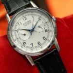 Close-up of the Citizen Classic AO9000-06B with black leather strap resting on a bright red cushion.