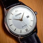 Close-up of the Citizen Corso Eco-Drive AW1236-03A, showcasing its refined silver dial, rose gold-tone hands, and date window.