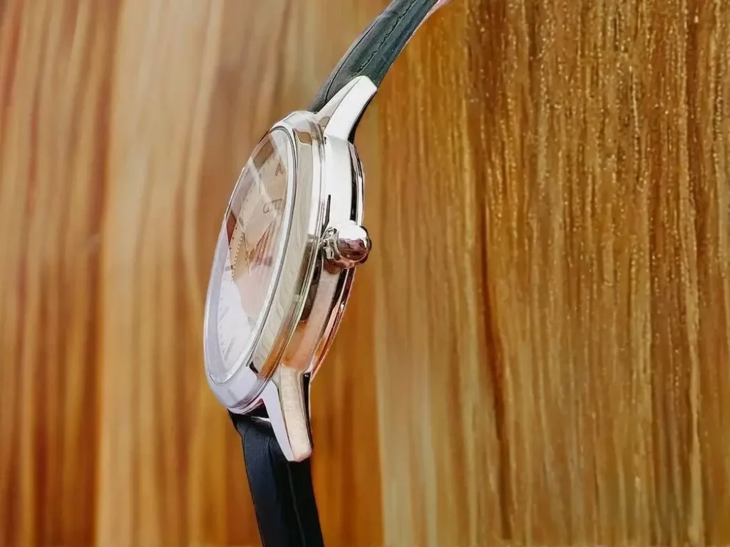 Side-angle shot of the Citizen Corso Eco-Drive AW1236-03A watch, showing its slim stainless steel case, crown, and slightly domed crystal against a wooden background.