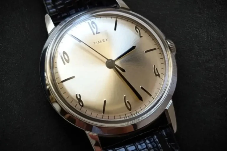 Close-up of Timex Marlin Hand-Wound TW2R47900 dial on a black leather surface.