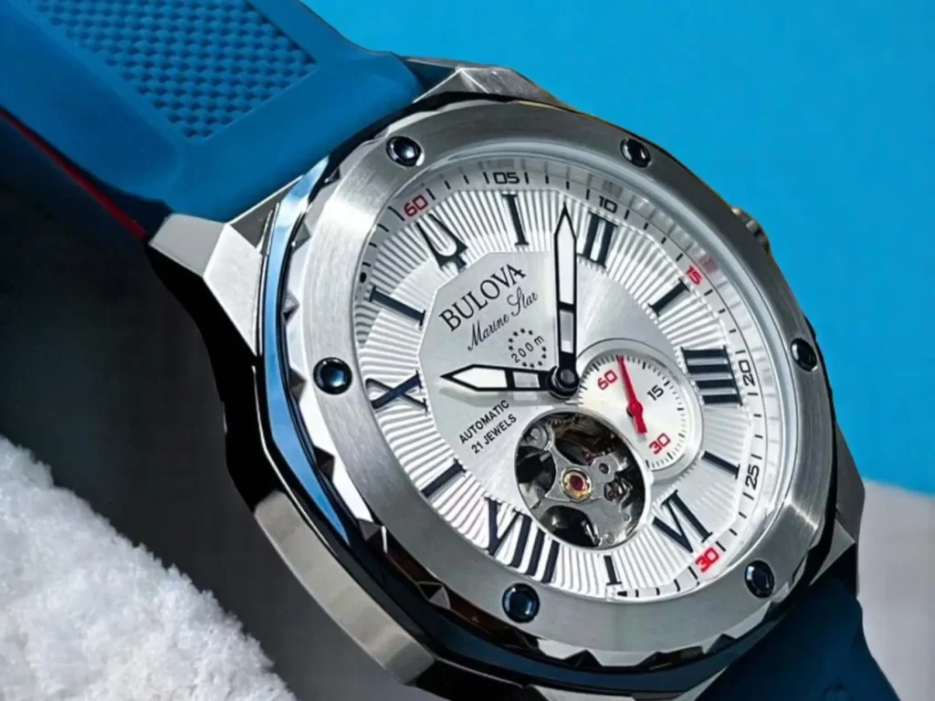 Close-up of a Bulova Marine Star 98A225, featuring a stainless steel case, silver textured dial, and a blue silicone strap.