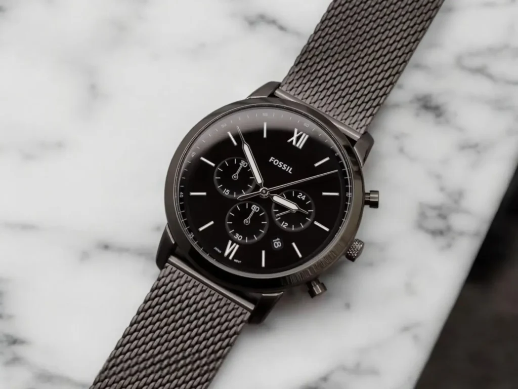 Fossil Neutra Chronograph FS5699 dress watch displayed on a white marble surface with gray veining in a modern, minimalist composition.