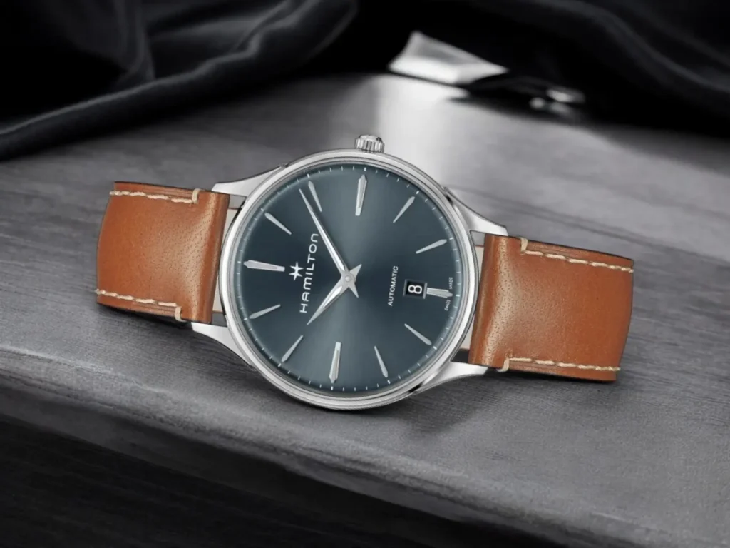 Hamilton Jazzmaster Thinline Auto dress watch displayed diagonally on a textured gray stone surface in a minimalist, sophisticated setting.