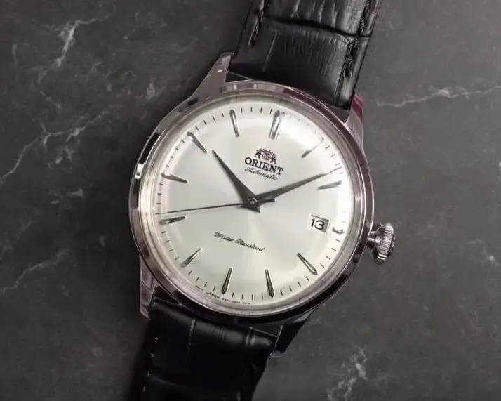 Front view of Orient Bambino Version 7 RA-AC0M03S10B watch on a dark gray marble surface.