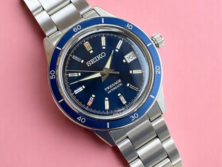 Seiko Presage Style60's SRPG05 with a blue sunburst dial and silver-tone markers, photographed against a pink background.