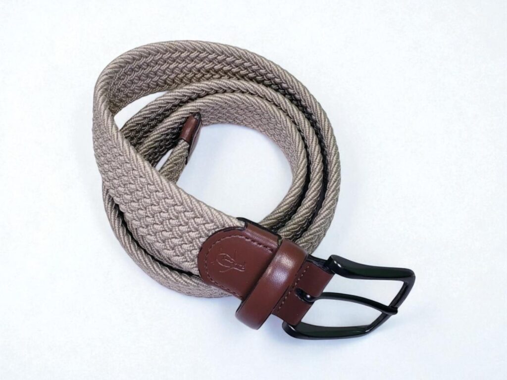 Braided beige belt with brown leather accents and a black metal buckle, coiled neatly on a white background.