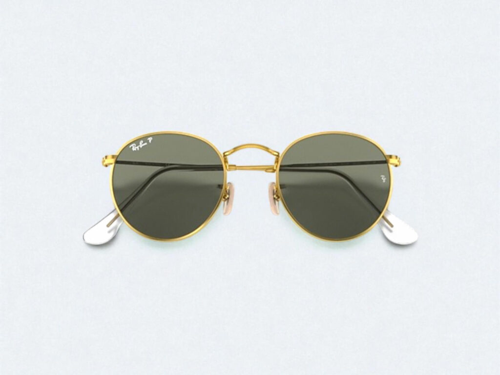 Ray-Ban Round sunglasses with gold frames and dark green lenses on a light background.