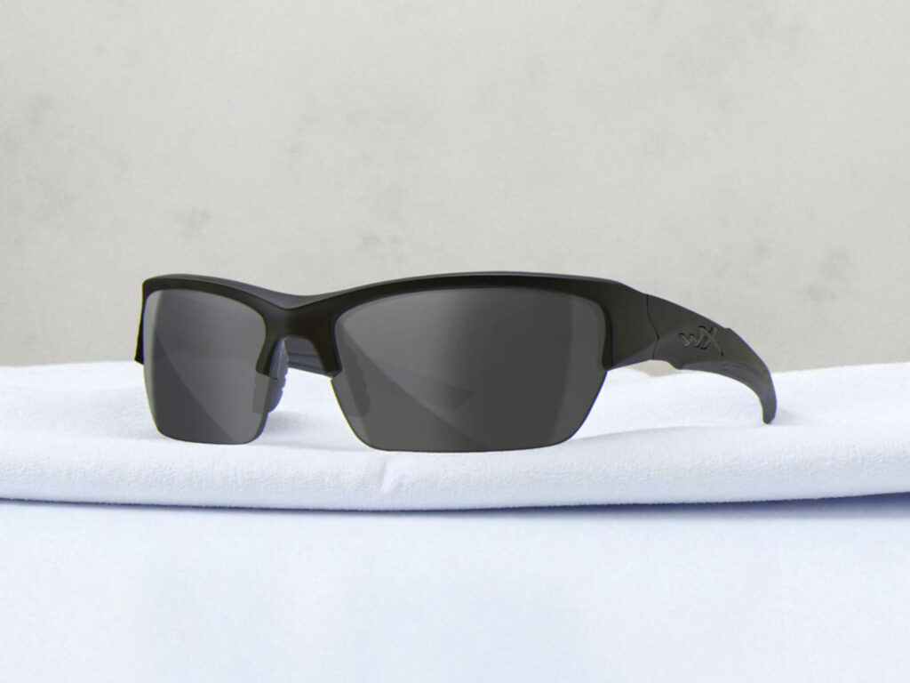 Wiley X WX Valor polarized sunglasses with reflective dark lenses, resting on a soft, light surface against a neutral background.