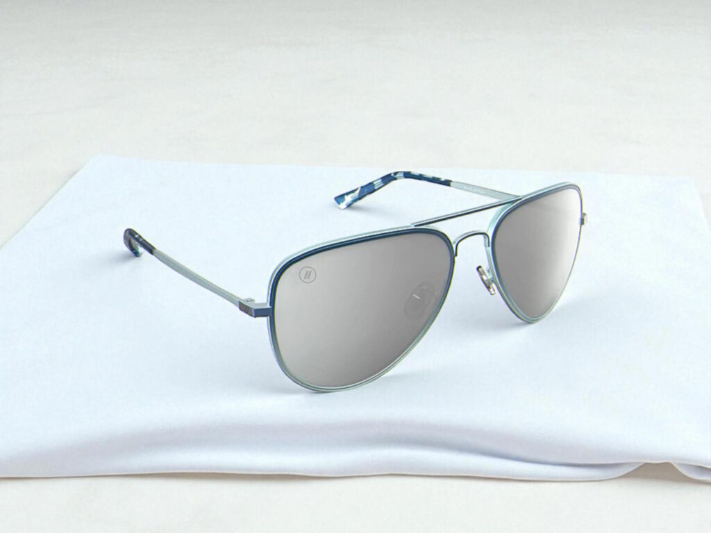 Blenders Eyewear A Series sunglasses with reflective lenses resting on a folded white cloth, set against a light background.