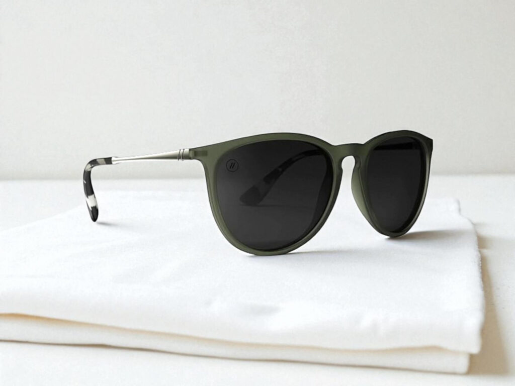 Blenders Eyewear North Park sunglasses with dark lenses rest on a folded white cloth against a neutral backdrop. 