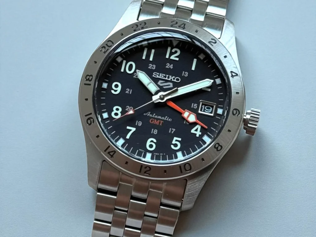 Seiko 5 GMT SSK023 resting on a gray surface.