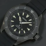 Seiko Prospex Automatic SRPL15 with luminous markers and hands, resting on a black surface.