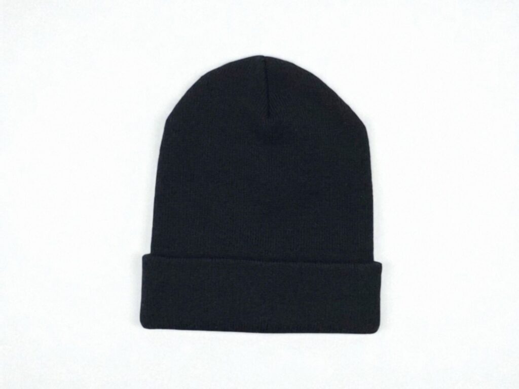 A plain black beanie with a folded edge is centered on a white background. 