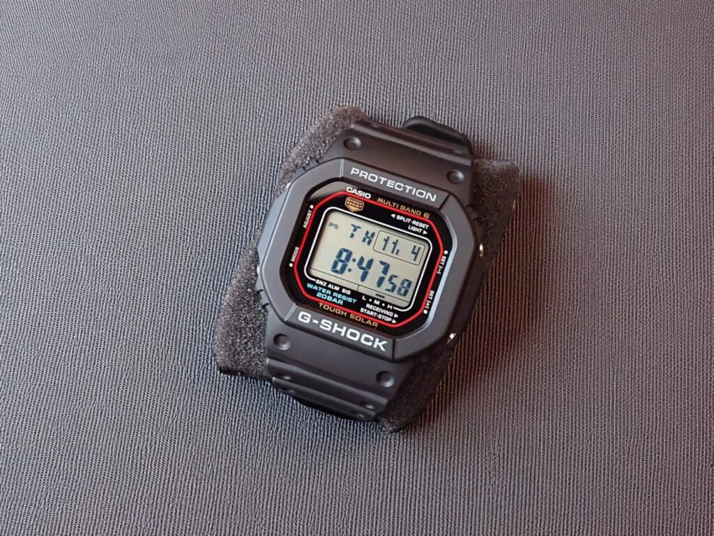 Digital G-Shock GW-M5610U watch on a gray textured surface, displaying time 8:47 and date Thursday, 11/4. 