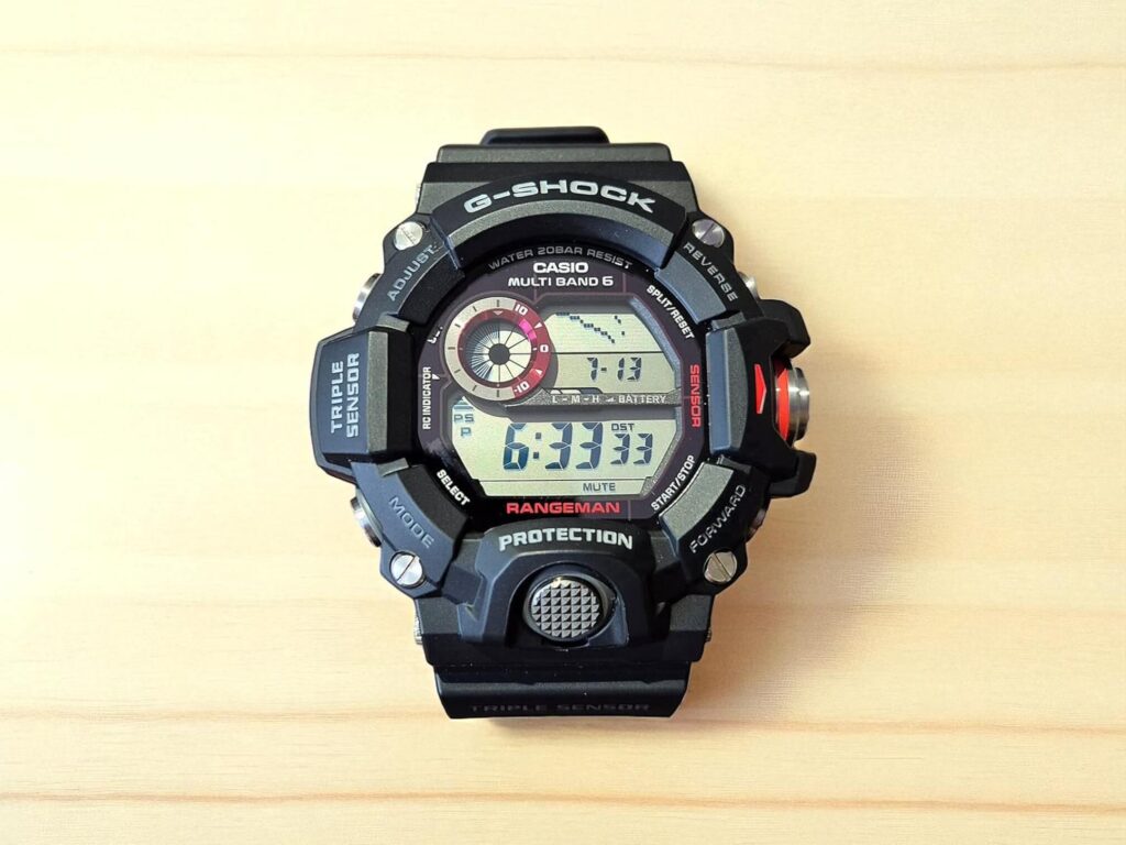 A black Casio G-Shock Rangeman watch is displayed on a light wood surface.