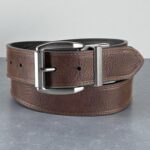 Rolled Levi's Reversible leather belt with a silver metal buckle on a gray surface.