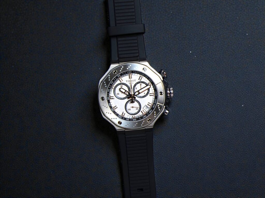 Tissot T-Race Chronograph 45mm watch with a sleek black strap, set against a dark background. 