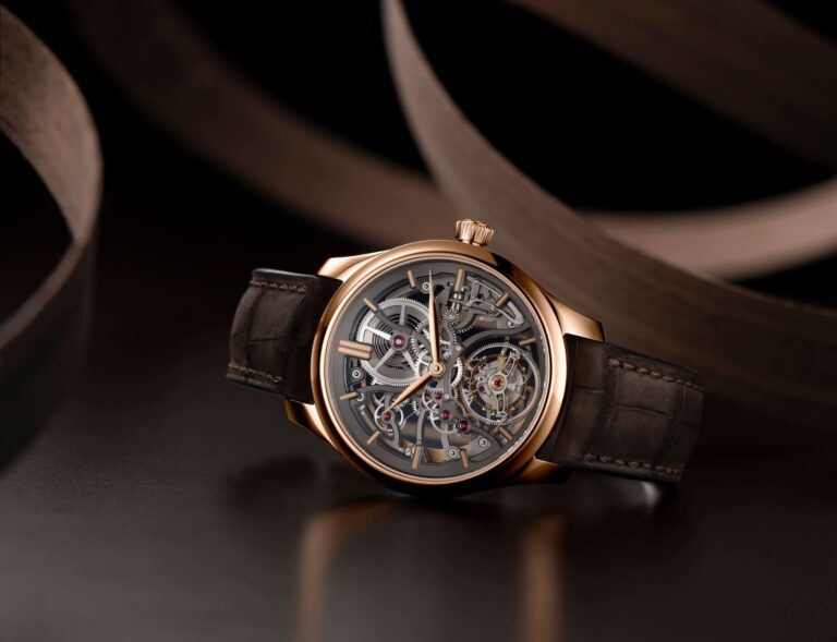 H. Moser & Cie. Endeavour Tourbillon luxurious skeleton watch with a gold case and intricate mechanical movements is displayed against a dark background.