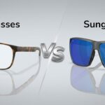 Comparison image of eyeglasses and sunglasses on a sleek, reflective surface. Eyeglasses on the left are brown and clear-lensed; sunglasses on the right have blue-tinted lenses.