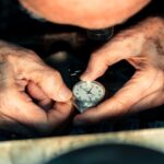 Close-up of an elderly person's hands carefully winding a mechanical wristwatch.